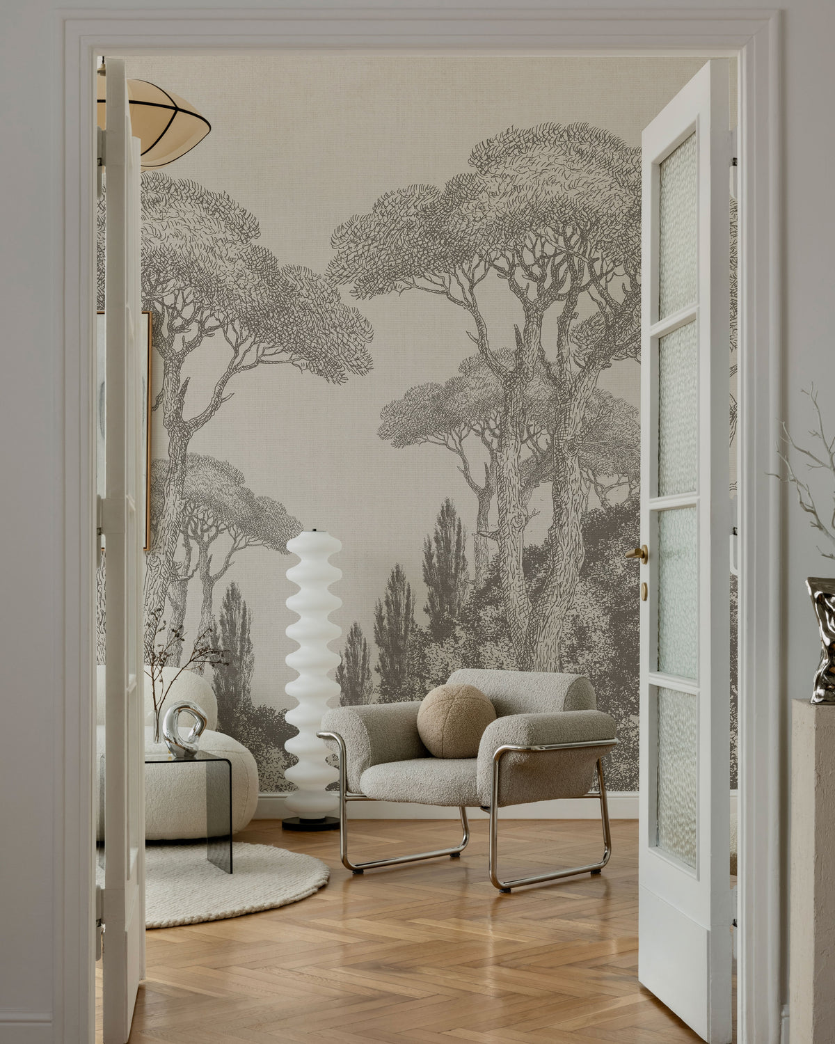 Neutral toile-style wallpaper with hand-drawn Mediterranean pine trees and layered forest landscape in soft beige tones