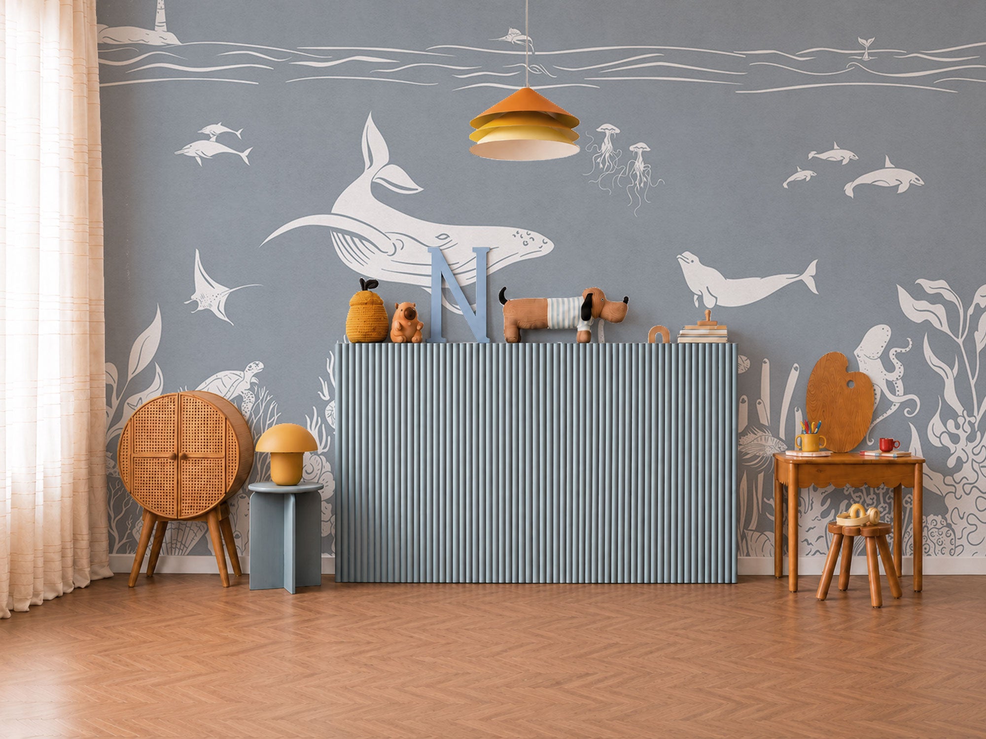 Underwater mural wallpaper in soft blue with whales, dolphins, sea life, and coral illustrations.