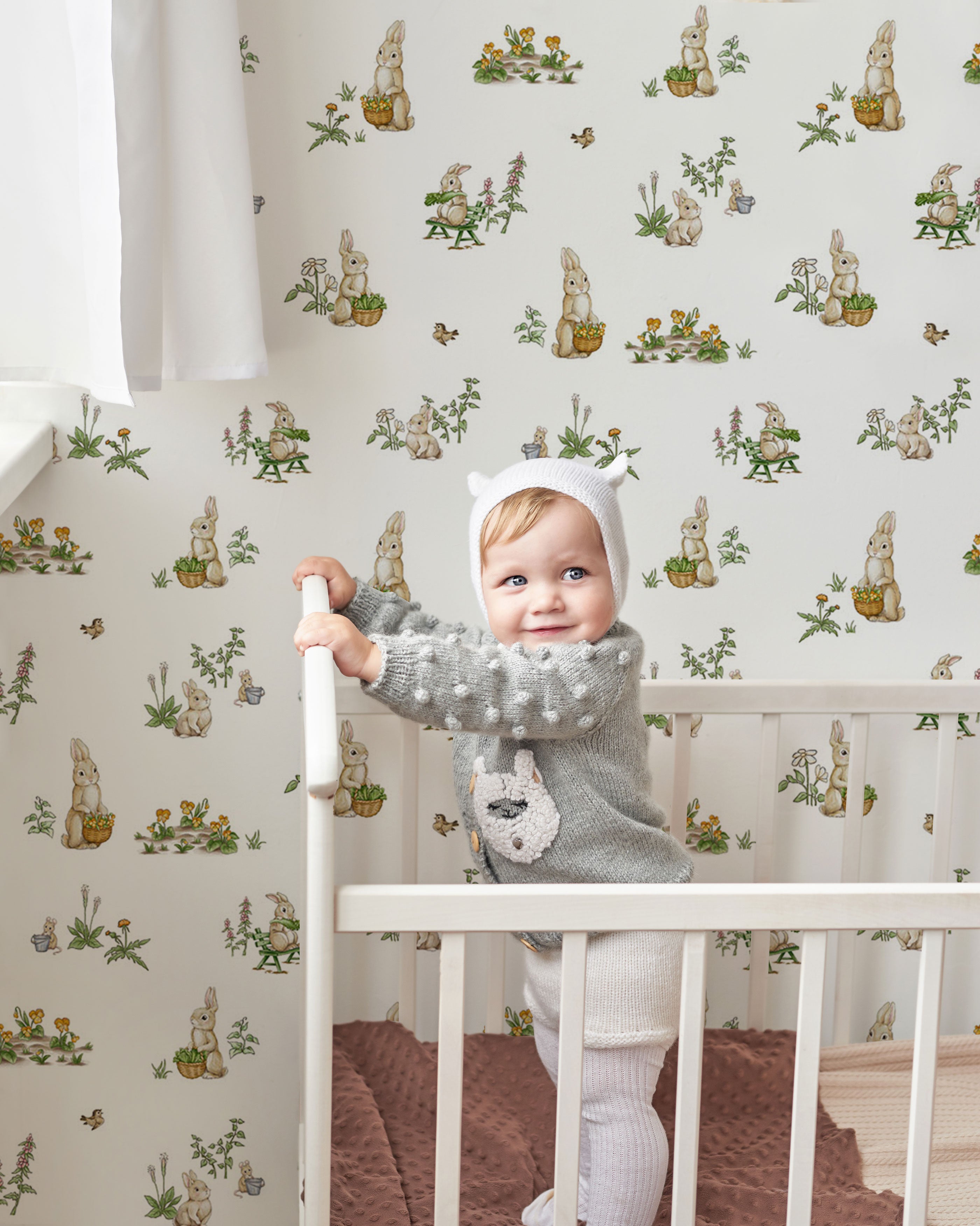 Pattern wallpaper with small illustrated bunnies, flowers and garden elements in soft neutral and green tones, designed for children’s interiors.
