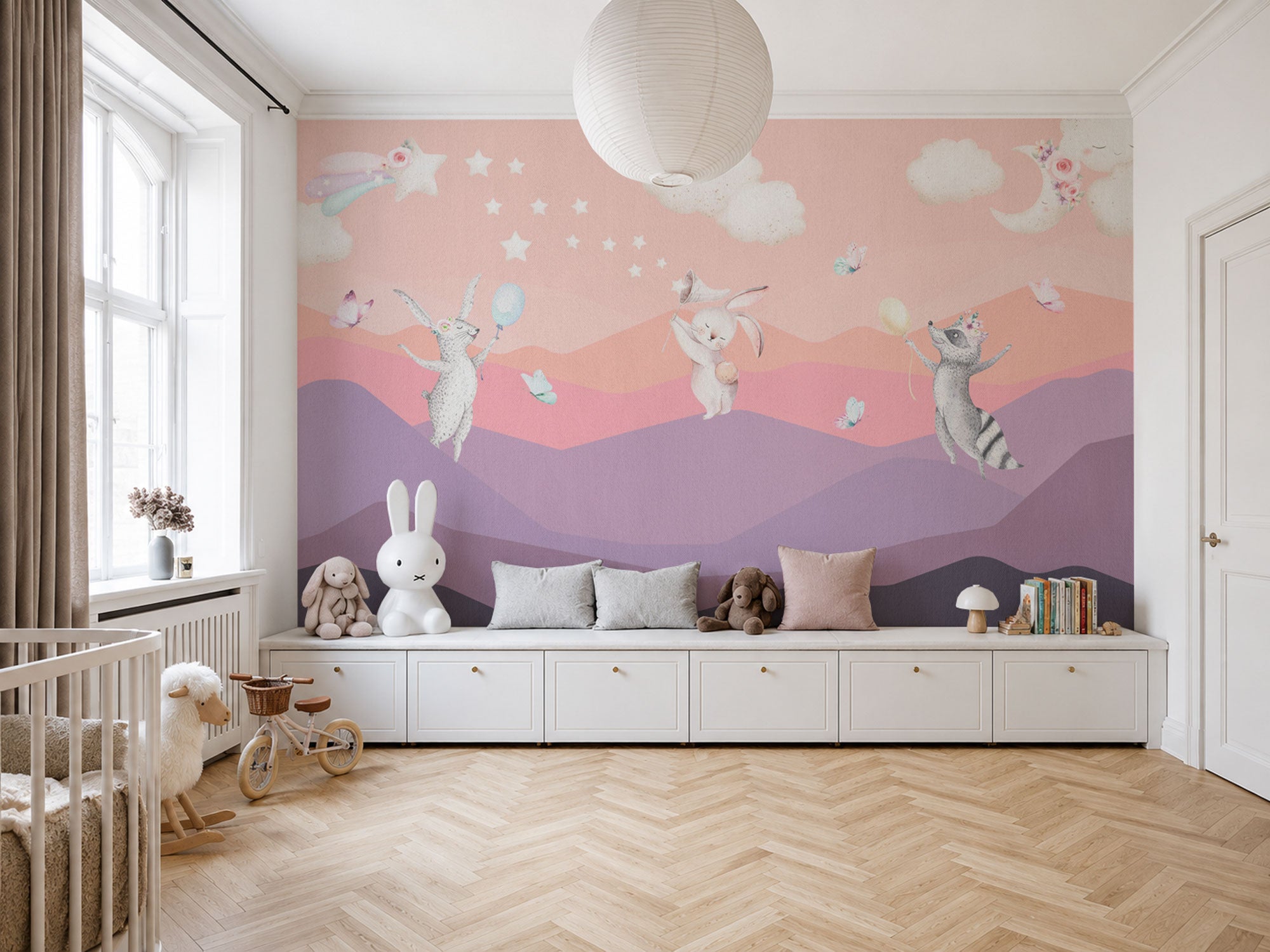 Pink pastel mural wallpaper with whimsical animals, balloons, stars, clouds, and dreamy layered hills in a soft hand-painted style.