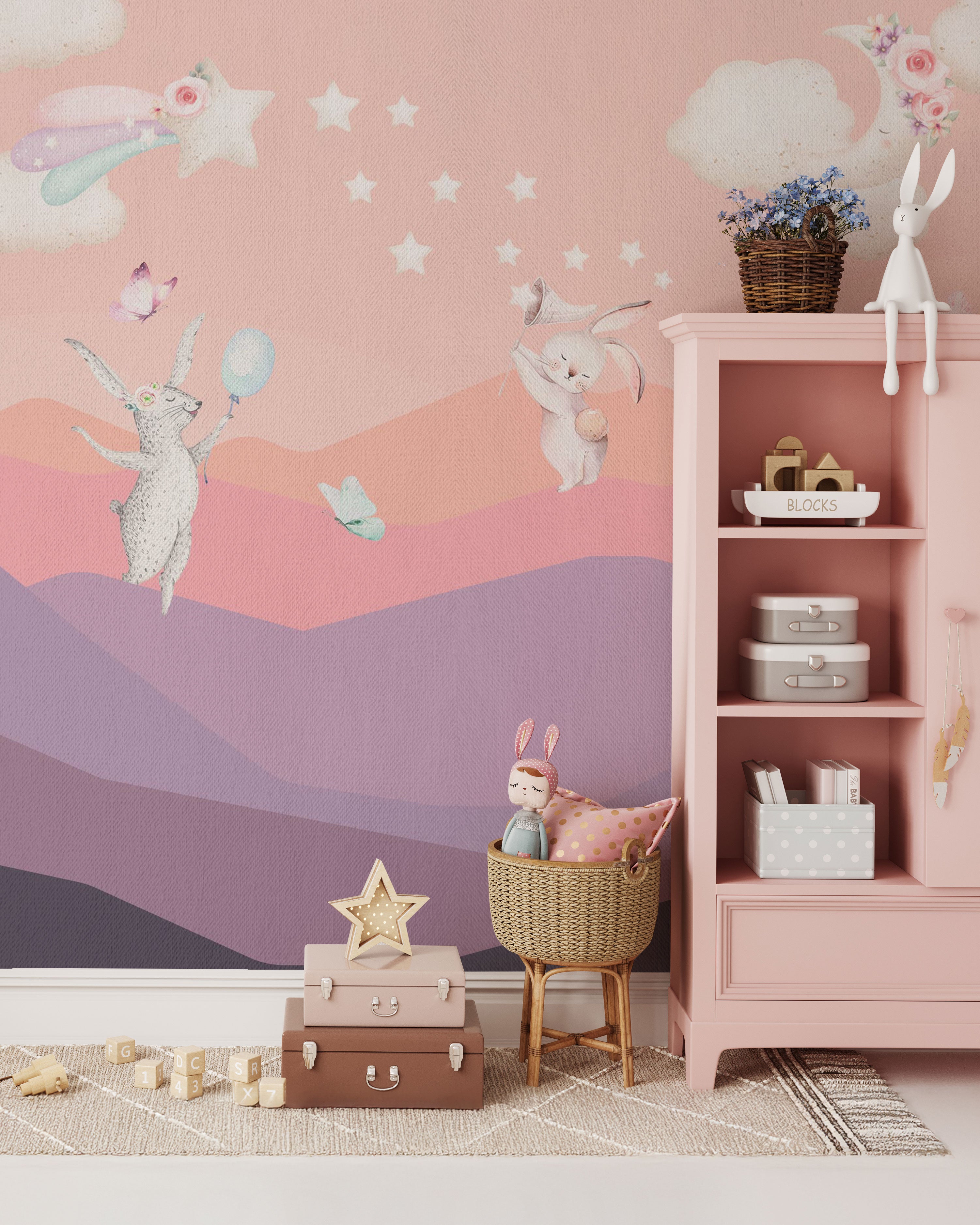 Pink pastel mural wallpaper with whimsical animals, balloons, stars, clouds, and dreamy layered hills in a soft hand-painted style.