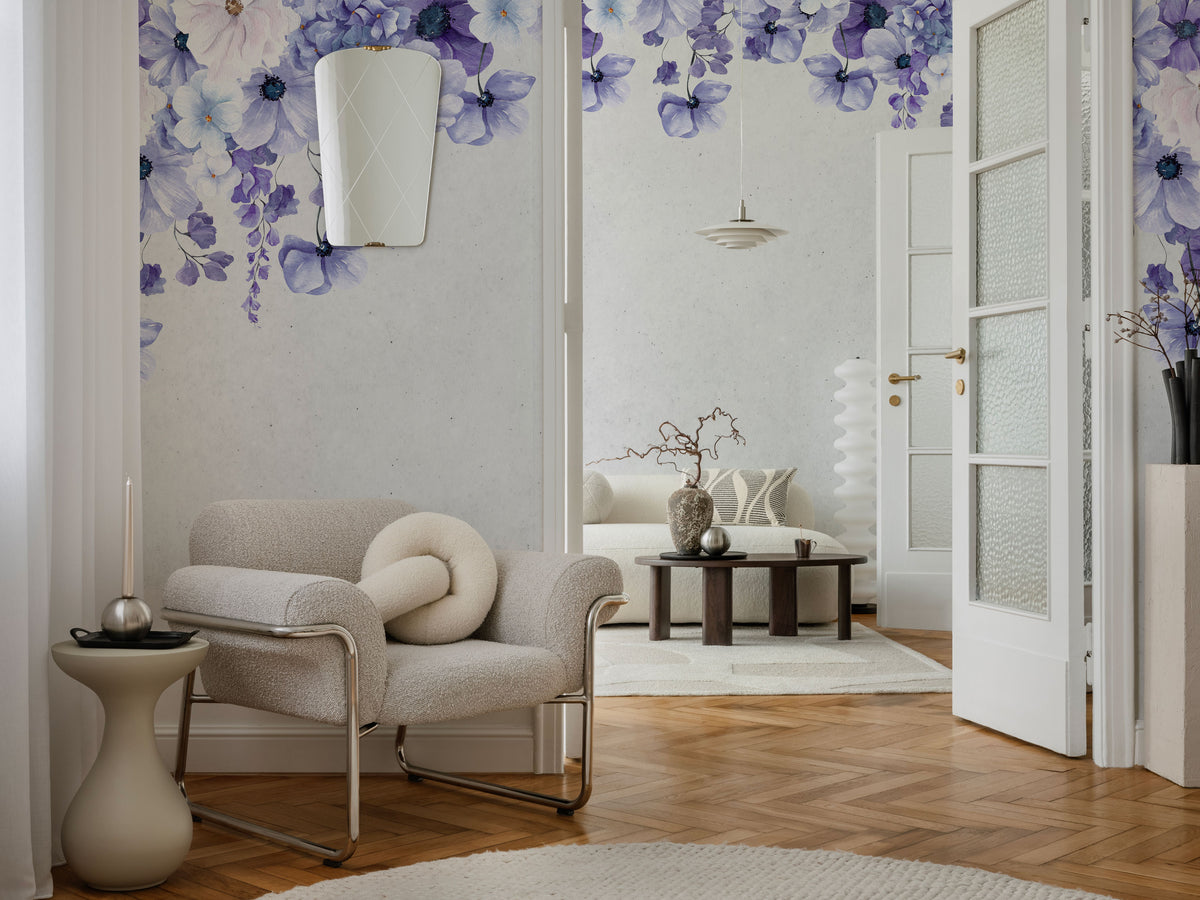 Floral wallpaper with a soft lavender and lilac flower border cascading from the top on a warm off-white textured background